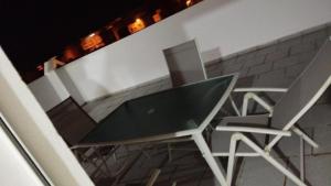 two chairs and a glass table on a balcony at AlMohit Larache in Larache