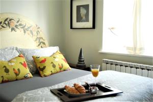 a tray of food on a bed with a drink and cookies at Hampton Court Snug Sleeps 6 - 5min Walk to Palace and Train in East Molesey