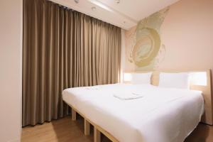 - une chambre avec un grand lit blanc devant une fenêtre dans l'établissement Park Central Sakura Hotel, à Osaka