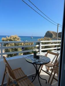 a table and chairs on a balcony with a view of the ocean at Chrisanthi Apartments in Archangelos