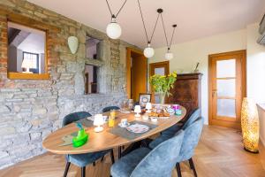 a dining room with a wooden table and blue chairs at Côté cour, côté source chambre d'hôtes in Chaudfontaine +44 photos
