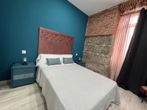a bedroom with a bed and a brick wall at Redondilla in Madrid