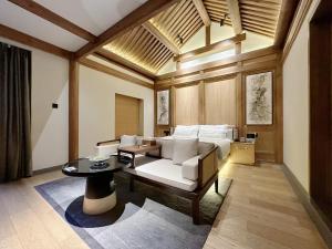 a living room with a bed and a table at 北京悦明元星空白塔景观四合院民宿 in Beijing
