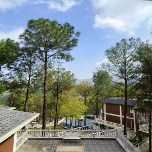 ein Blick auf ein Gebäude mit Bäumen im Hintergrund in der Unterkunft WelcomHeritage Santa Roza Kasauli in Kasauli