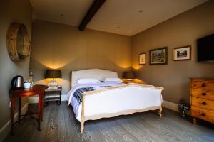 a bedroom with a bed and a desk and a television at Chippenham Park Garden Rooms in Chippenham +22 photos