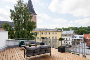 a balcony with two couches on a wooden deck at Tempus Te Premium Duo Lofts Tartu - private cinema, gym and terrace in Tartu