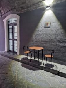 un tavolo e due sedie in una stanza con un muro di LND Room a Catania