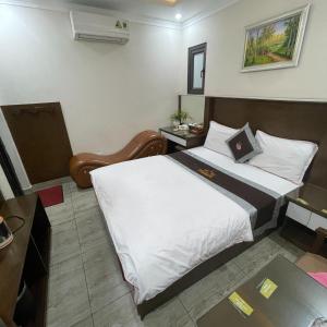 ein Hotelzimmer mit einem Bett und einem Schreibtisch in der Unterkunft HOÀNG GIA HOTEL 2 - 202/16 Đường Cổ Linh - by Bay Luxury in Hanoi