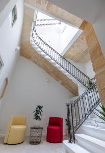 a staircase with two chairs and a red chair at The Glen Residences in Senglea