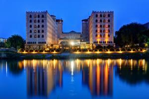 a building with a reflection in the water at night at Suhan Cappadocia Hotel & Spa in Avanos