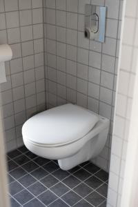 La salle de bains carrelée est pourvue de toilettes blanches. dans l'établissement Charmante la petite maison, à Potsdam