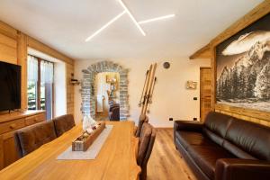 een woonkamer met een houten tafel en een bank bij Aiguille Noire La Maison de Courma in Courmayeur