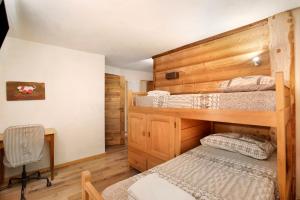 a bedroom with two bunk beds and a desk at Aiguille Noire La Maison de Courma in Courmayeur