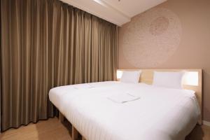 Postel nebo postele na pokoji v ubytování Park Central Sakura Hotel