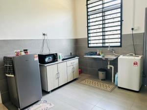 a kitchen with a refrigerator and a sink in it at Modern Style Home, Pekan WIFI Netflix in Pekan
