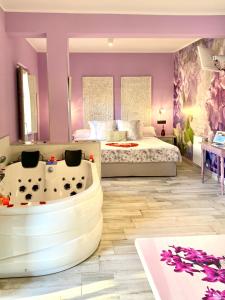 een slaapkamer met een bad en een bed met paarse muren bij Akla Suites con Jacuzzi Santillana in Santillana del Mar