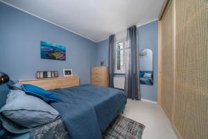 a blue bedroom with a bed and a window at Indaco in Udine