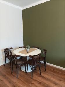 einen Tisch und Stühle in einem Zimmer mit grüner Wand in der Unterkunft Compact Apartment Sleeps 6 + Great Location in Prag