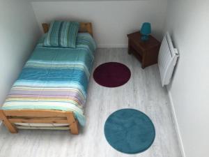 a small bedroom with a bed and two rugs at Gite Saint Martin in Pargny-lès-Reims
