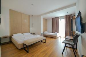 1 dormitorio con 1 cama y 1 silla en Hotel Central en Vlorë