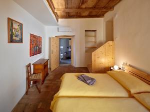 a bedroom with a yellow bed and a desk at Bed and Breakfast Chiarina in Mendrisio