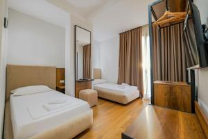 Habitación de hotel con 2 camas y espejo en Hotel Central en Vlorë