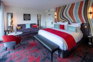 een hotelkamer met een groot bed en een bank bij Hôtel Garrigae Villa La Florangerie in Straatsburg