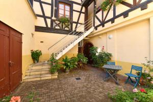 a courtyard of a building with stairs and plants at Jeannette in Ribeauvillé