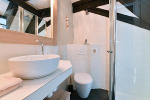 uma casa de banho com um lavatório branco e um WC. em Jaennette em Ribeauvillé