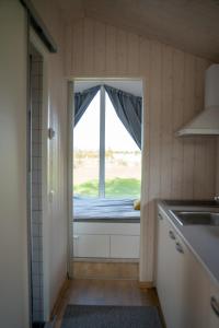 eine Küche mit einem Fenster in einem kleinen Zimmer in der Unterkunft Charmante la petite maison in Potsdam