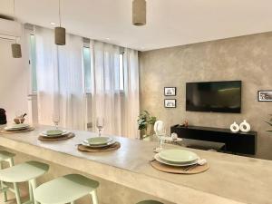 a kitchen with a table with chairs and a television at Baïa Appartment in La Marsa