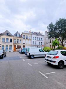a parking lot with cars parked in front of buildings at Appartement Hypercentre 203 + WIFI +INDEPENDANT+TOILETTE CUISINE SALLE DE BAIN PRIVATIVE in Valenciennes