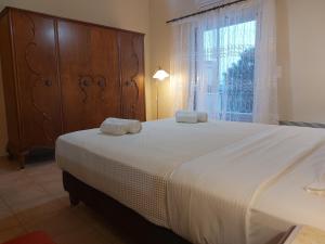 sypialnia z dużym łóżkiem z dwoma ręcznikami w obiekcie PLEIADES lUXURY APARTMENTS w mieście Porto Heli
