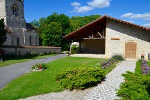 une église avec une cour herbeuse à côté d'un bâtiment dans l'établissement Gite Saint Martin, à Pargny-lès-Reims
