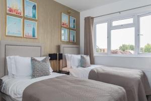 Una habitación de hotel con dos camas y dos ventanas. en Luxurious 4-Bed Holiday Retreat, en Finchley