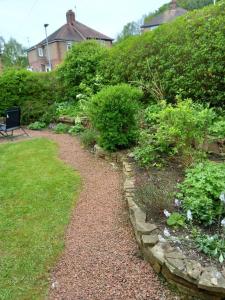 a garden with a stone path and bushes at The Side - Hexham in Hexham
