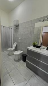 ein Bad mit einem WC, einem Bidet und einem Waschbecken in der Unterkunft House Capodichino in Neapel