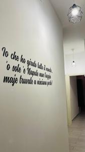 eine Wand mit einem Schreiben an der Wand in der Unterkunft House Capodichino in Neapel