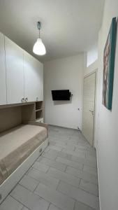 Cette chambre blanche dispose d'un lit et d'une porte. dans l'établissement House Capodichino, à Naples