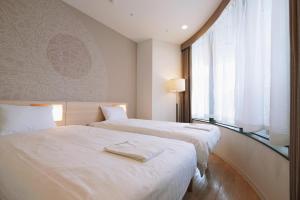 a hotel room with two beds and a window at Park Central Sakura Hotel in Osaka +108 photos