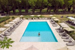 an overhead view of a pool with a person in the water at Moulin de Vernègues Hôtel & Spa in Mallemort