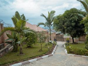 een tuin met palmbomen en een huis bij Sunset 4 bedroom Family Villa in Kigali