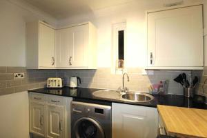 a kitchen with a sink and a washing machine at The Eagles Nest in Norwood