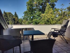 a patio with a table and chairs on a roof at Spacious & comfortable guestrooms w private bathrooms near Koelnmesse & Lanxess Arena, free parking, highspeed WiFi in Cologne