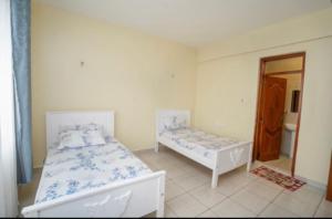 Säng eller sängar i ett rum på Sydney Residence, Parklands, Nairobi