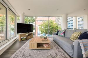 ein Wohnzimmer mit einem grauen Sofa und einem TV in der Unterkunft Convenient - ExCel London - O2- 3 Bedroom Apartment in London
