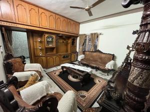 een woonkamer met meubilair en een plafond bij N A S HOMESTAY in Mysore