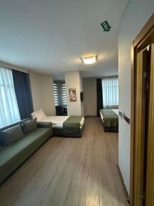 イスタンブールにあるHotel Atabayのベッド2台とソファが備わるホテルルームです。