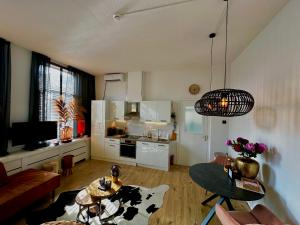 a living room with a table and a kitchen at Residentie de Eikhof in Hengelo