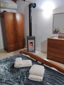 a bedroom with a fireplace and a bed with towels at Panthea Cottage in Stavroupoli